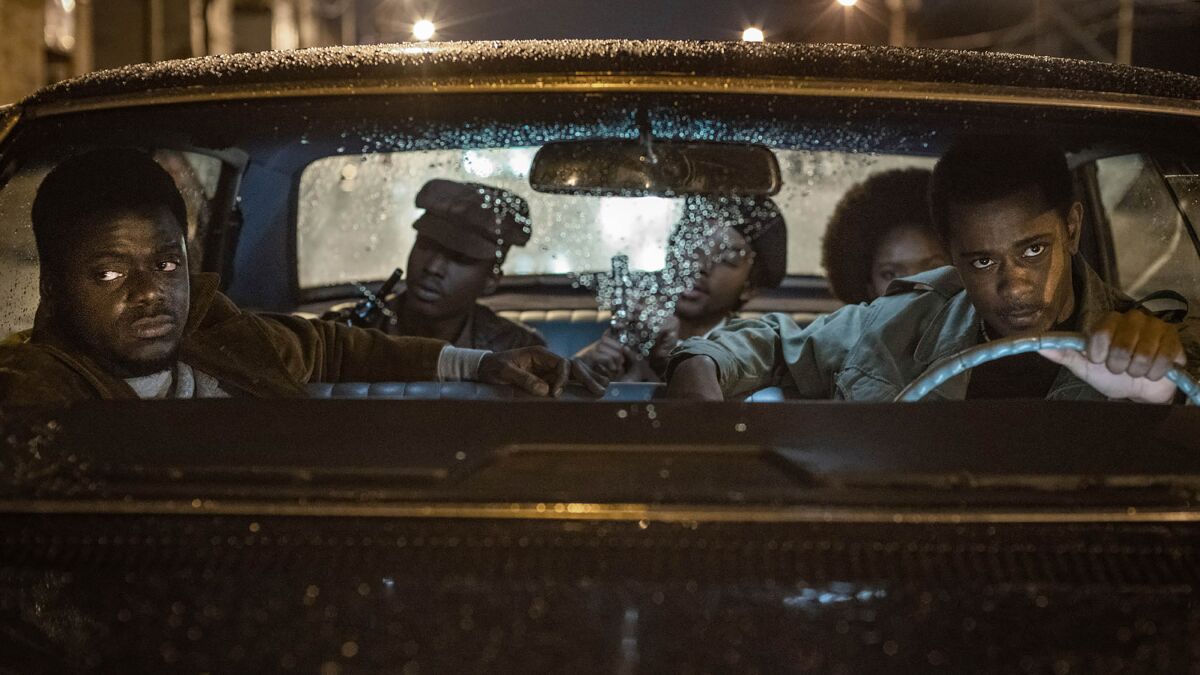 Daniel Kaluuya at left and LaKeith Stanfield behind the wheel of a car in a scene from "Judas and the Black Messiah." 