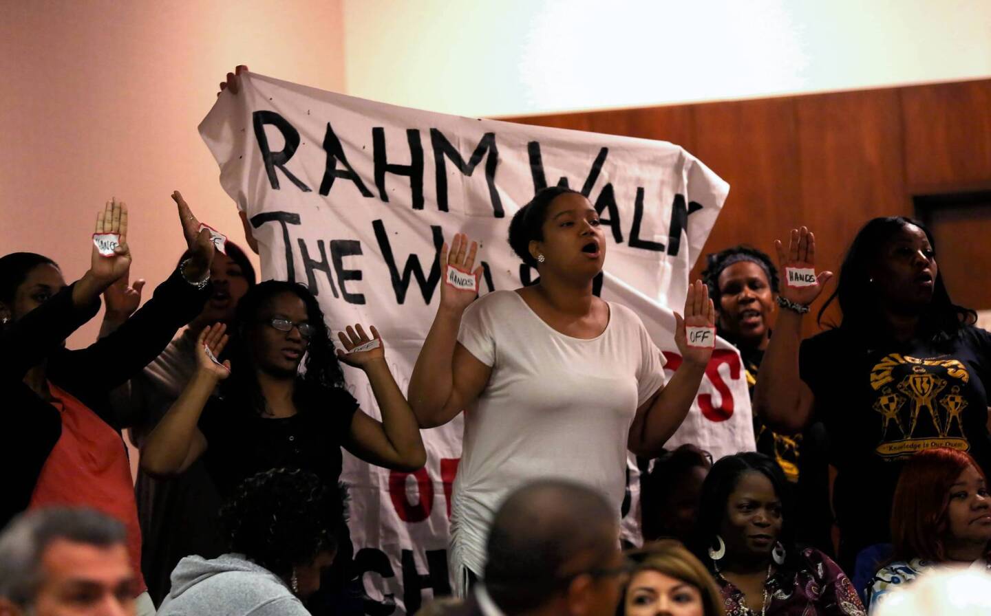 Demonstrators from Walk the Walk interrupt a City Council meeting to shout slogans concerning upcoming school closings. The group was ushered out of the chambers.