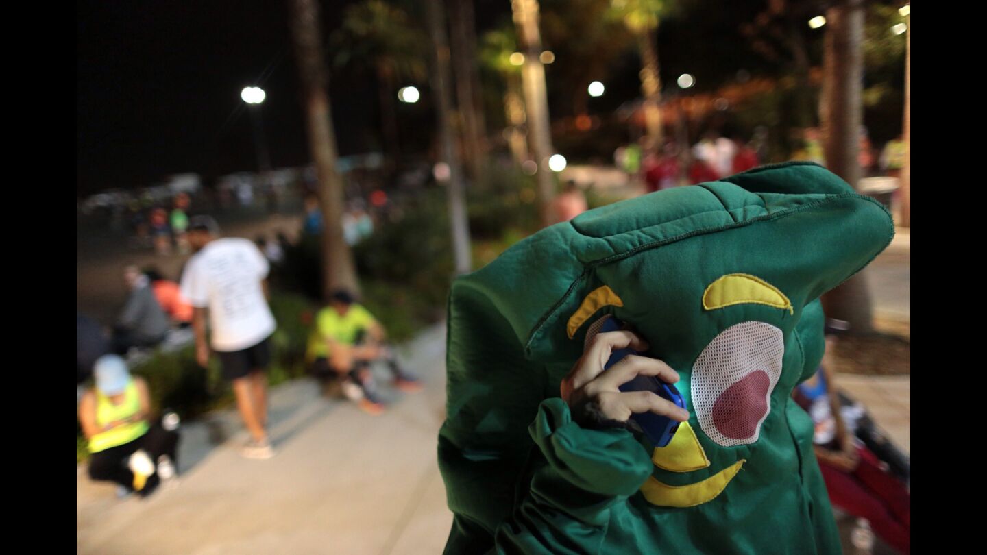 A runner in a Gumby costume talks on his cellphone at the start of the 30th Los Angeles Marathon.