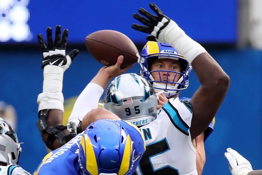 Rams quarterback Matthew Stafford passes under pressure from the Carolina defense