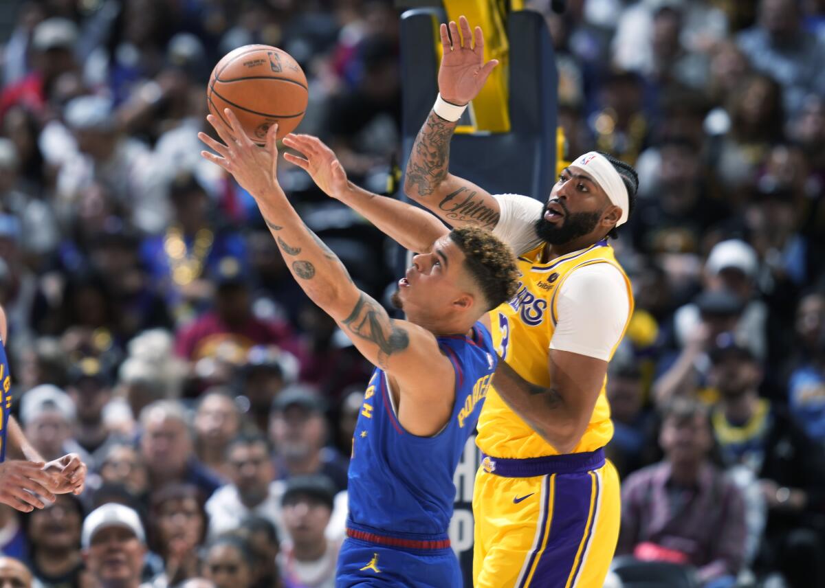 Denver Nuggets forward Michael Porter Jr. pulls in a rebound next to Lakers forward Anthony Davis.