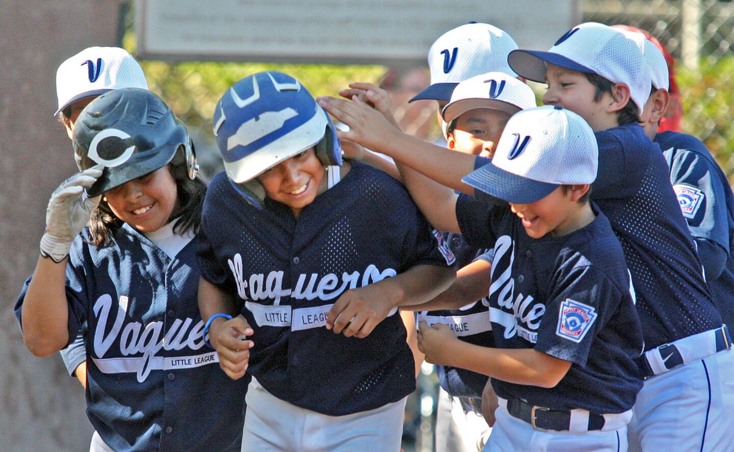 Vaquero's Raymond Cejudo is greeted at home plate after hitting a two-run homerun against Tujunga in the 10-11 district all-star championship at Babe Herman Field in Glendale on Tuesday, July 8, 2014. The Vaquero won the game to win the championship.