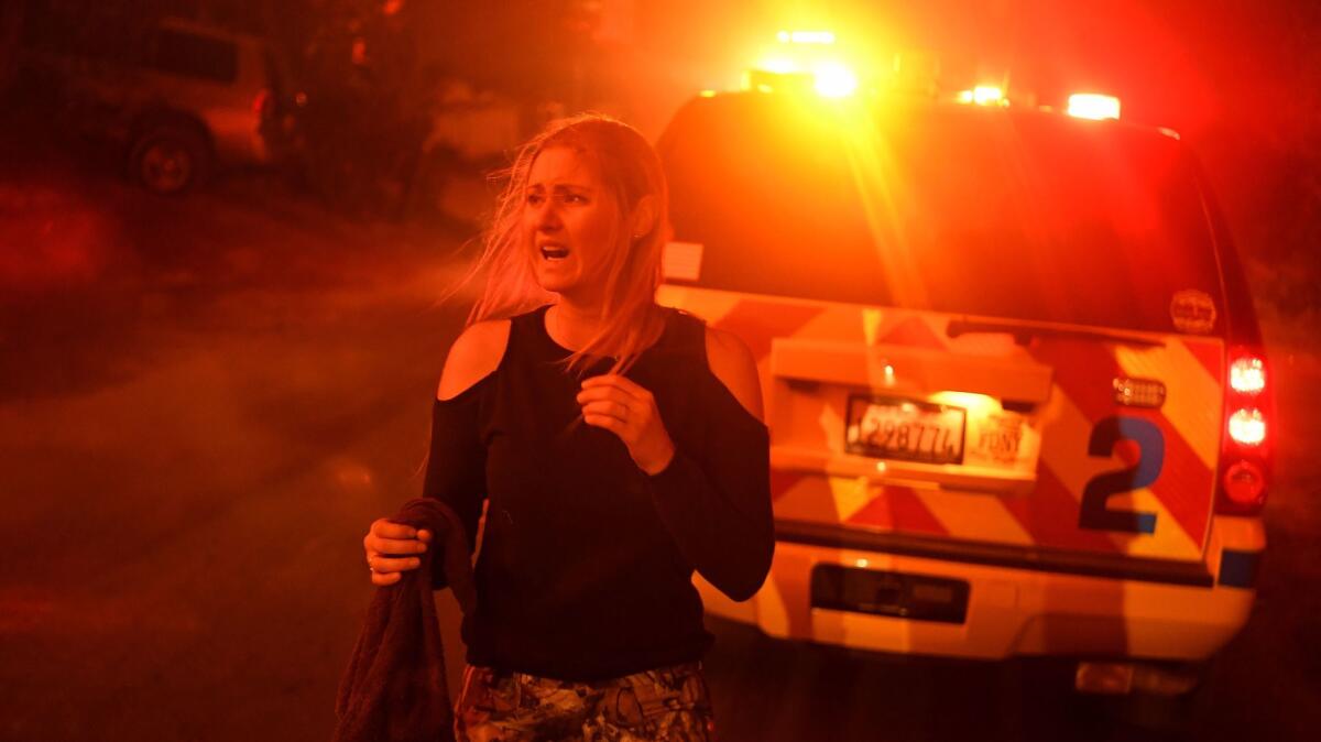 A scared and confused resident can't find her ride as the Thomas fire approaches the town of La Conchita early Thursday morning.