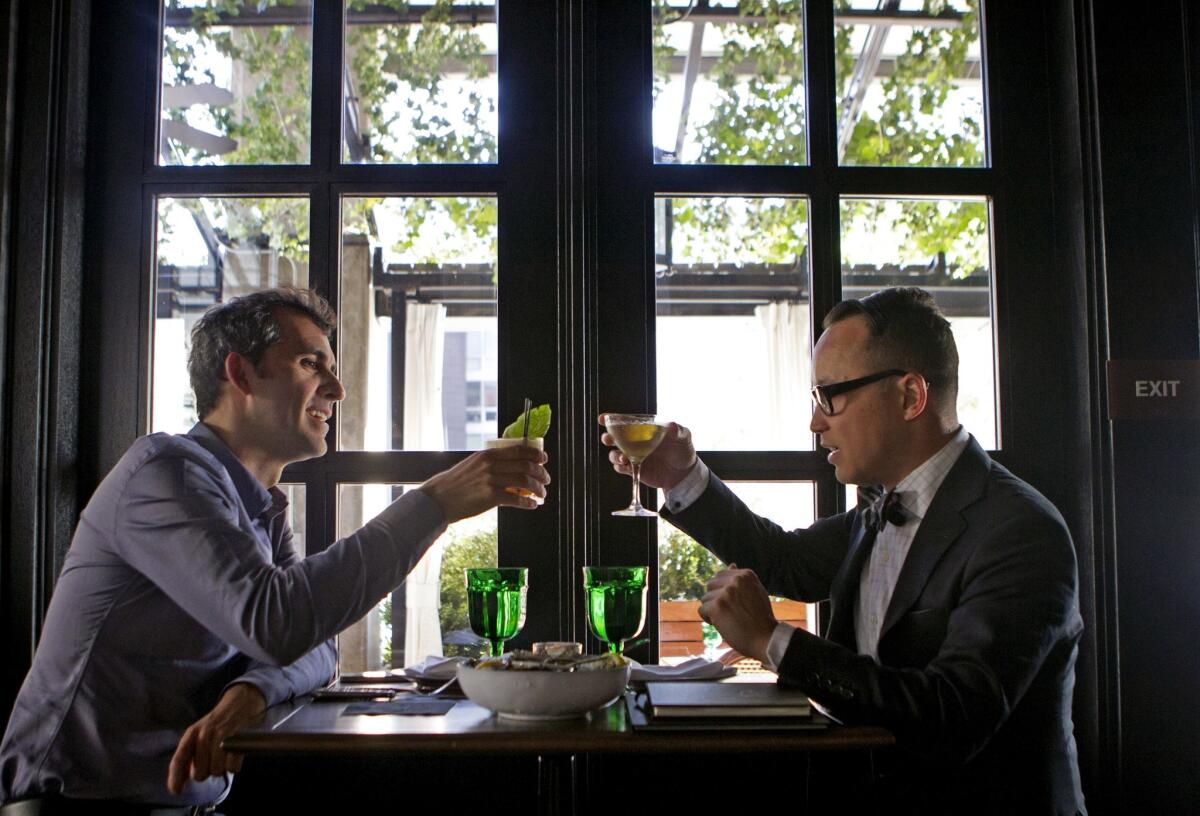 Brad Gwinn, left, and John Wirfs toast before sipping on their drinks at Faith & Flower in downtown L.A. The restaurant has launched a new three-course lunch menu for $18.