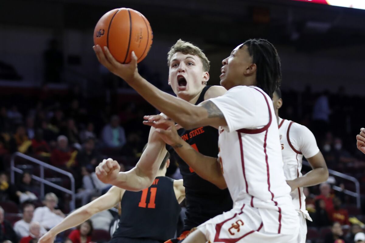 Southern California guard Boogie Ellis, right, drives to the basket against Oregon State forward Tyler Bilodeau during the second half of an NCAA college basketball game in Los Angeles, Sunday, Dec. 4, 2022. (AP Photo/Alex Gallardo)