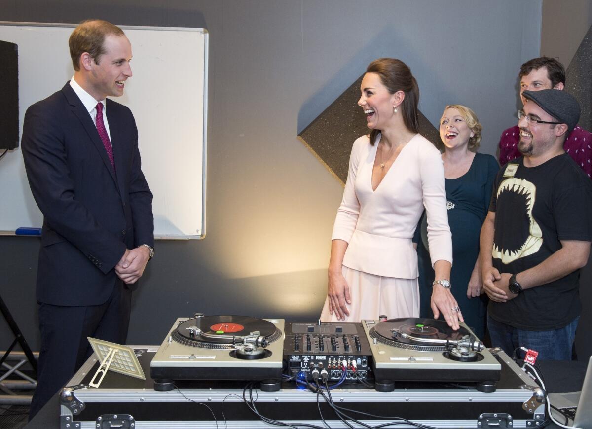 Catherine, Duchess of Cambridge and Prince William, Duke of Cambridge laugh as they are shown how to play on DJ decks at the Northern Sound System, a youth community center in a suburb of Adelaide, Australia.