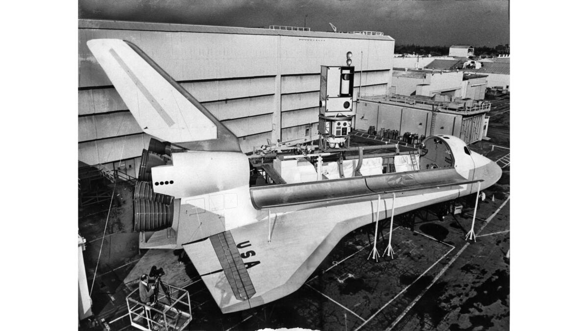 Feb. 5, 1975: A full-size mockup of the space shuttle with satellite emerging for placement into orbit, on display at North American Rockwell in Downey.