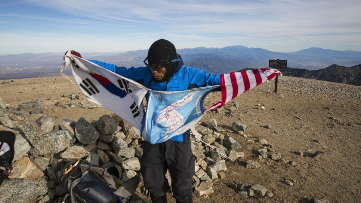 Sam Kim unfurls flags on the summit of Mt. Baldy, the highest point in the San Gabriel Mountains at 10,064 feet.