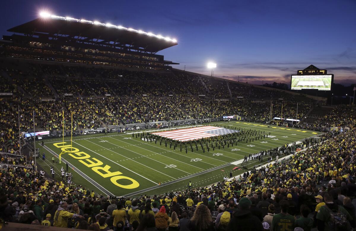 The Oregon Marching Band displays a giant United States flag on the field at Autzen Stadium before a game against Colorado.