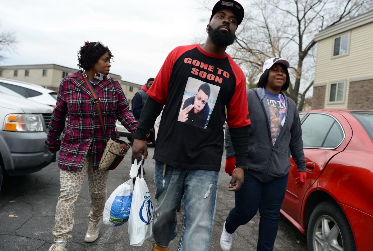 Michael Brown Sr., center, the father of 18-year-old Michael Brown, who was shot dead by a police officer, distributes turkey for Thanksgiving to neighbors.