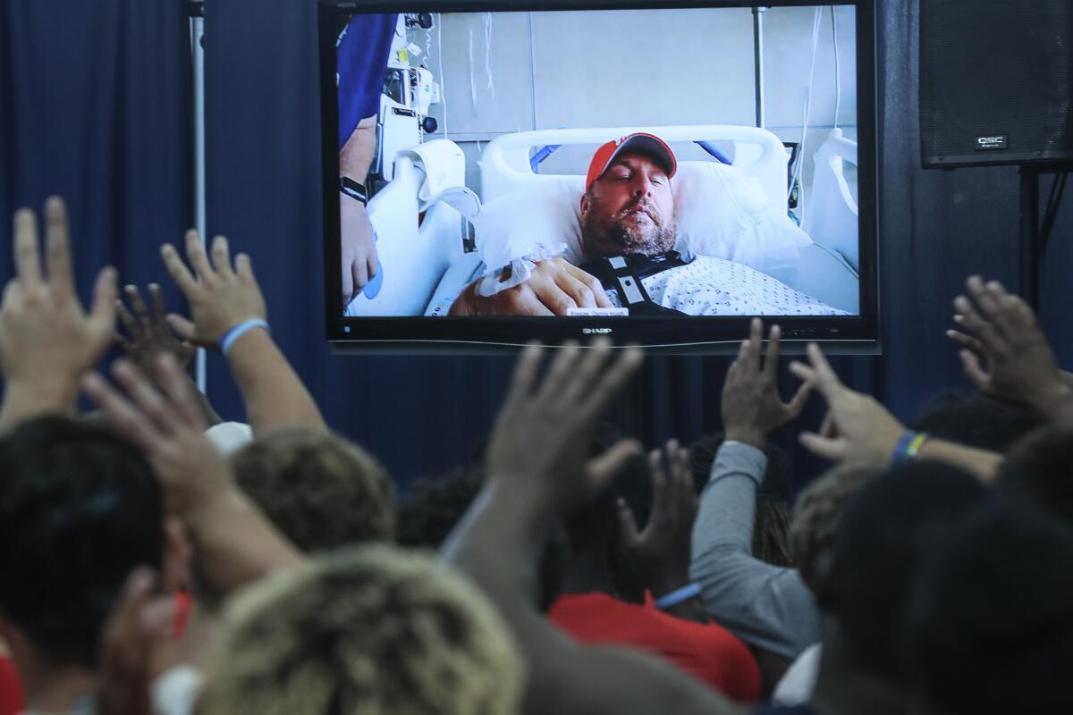 Liberty football players wave goodbye to coach Hugh Freeze at the conclusion of a video conference.