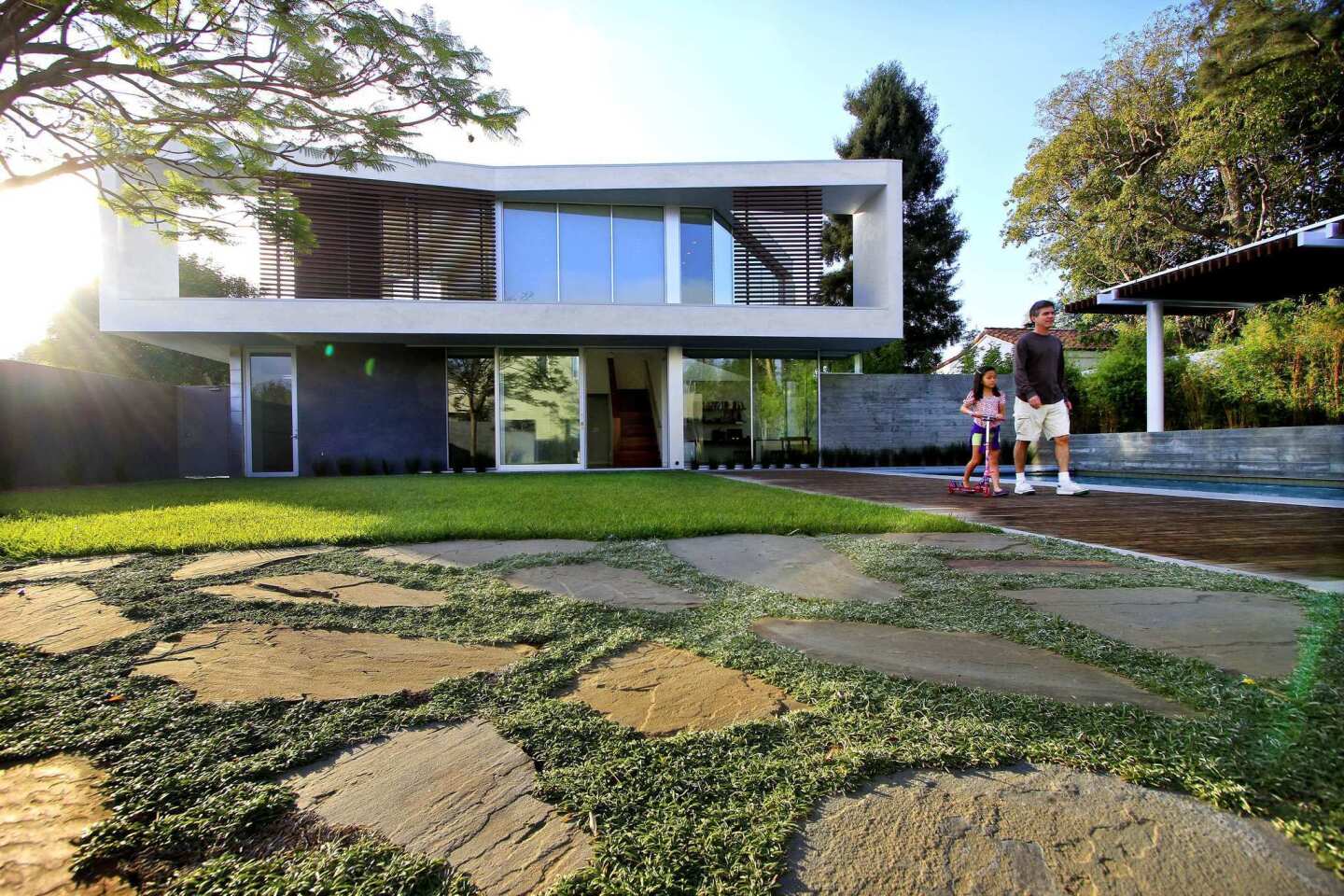 Craig Ehrlich walks with daughter Leah, 7, in front of the new house by architects John Friedman and Alice Kimm.