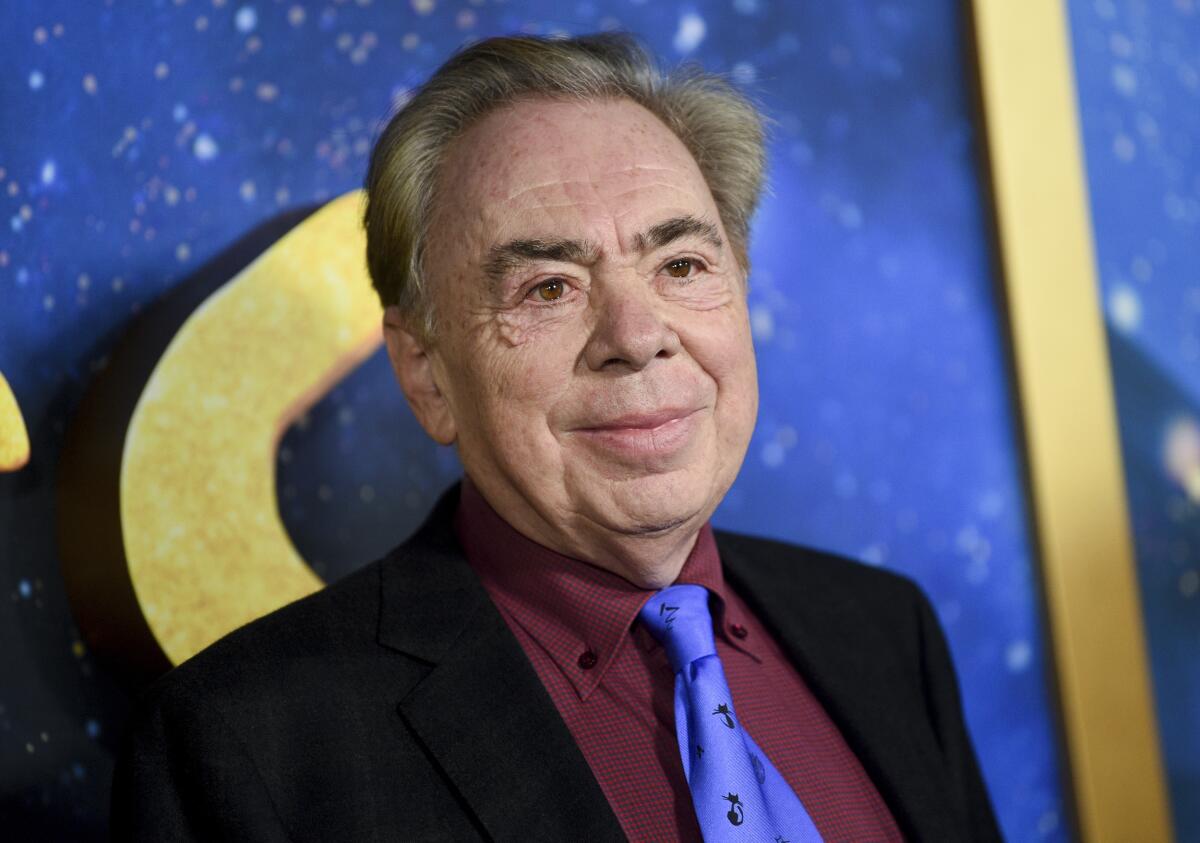 An older man poses in a black suit and purple tie