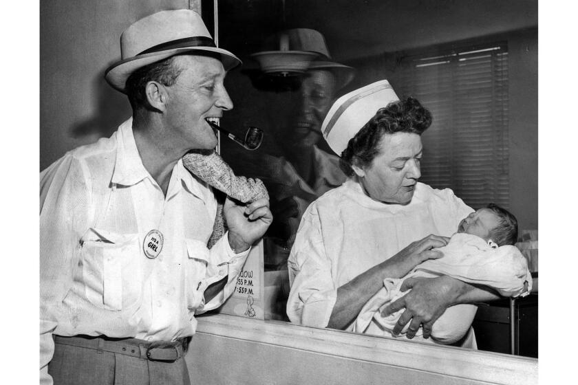 Sept. 15, 1959: Singer Bing Crosby smiles for his first and only daughter, Mary Frances, held by nurse Sadie Neal at Queen of Angels Hospital in Los Angeles.