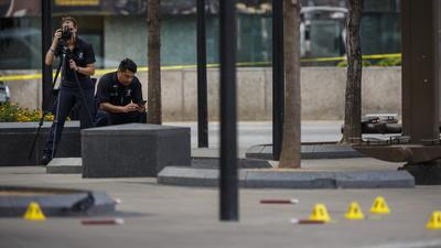 Investigators document the crime scene outside El Centro College in Dallas, where a sniper shot 12 police officers, killing five of them.