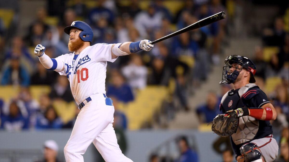 Justin Turner hits a three-run home run in front of Atlanta Braves catcher Tyler Flowers during the eighth inning at Dodger Stadium on May 7.