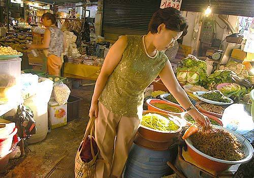 NEW LIFE IN SEOUL: Kim Hui Suk shops at a market near her workplace. She watched her husband, son and mother-in-law starve to death in the North.