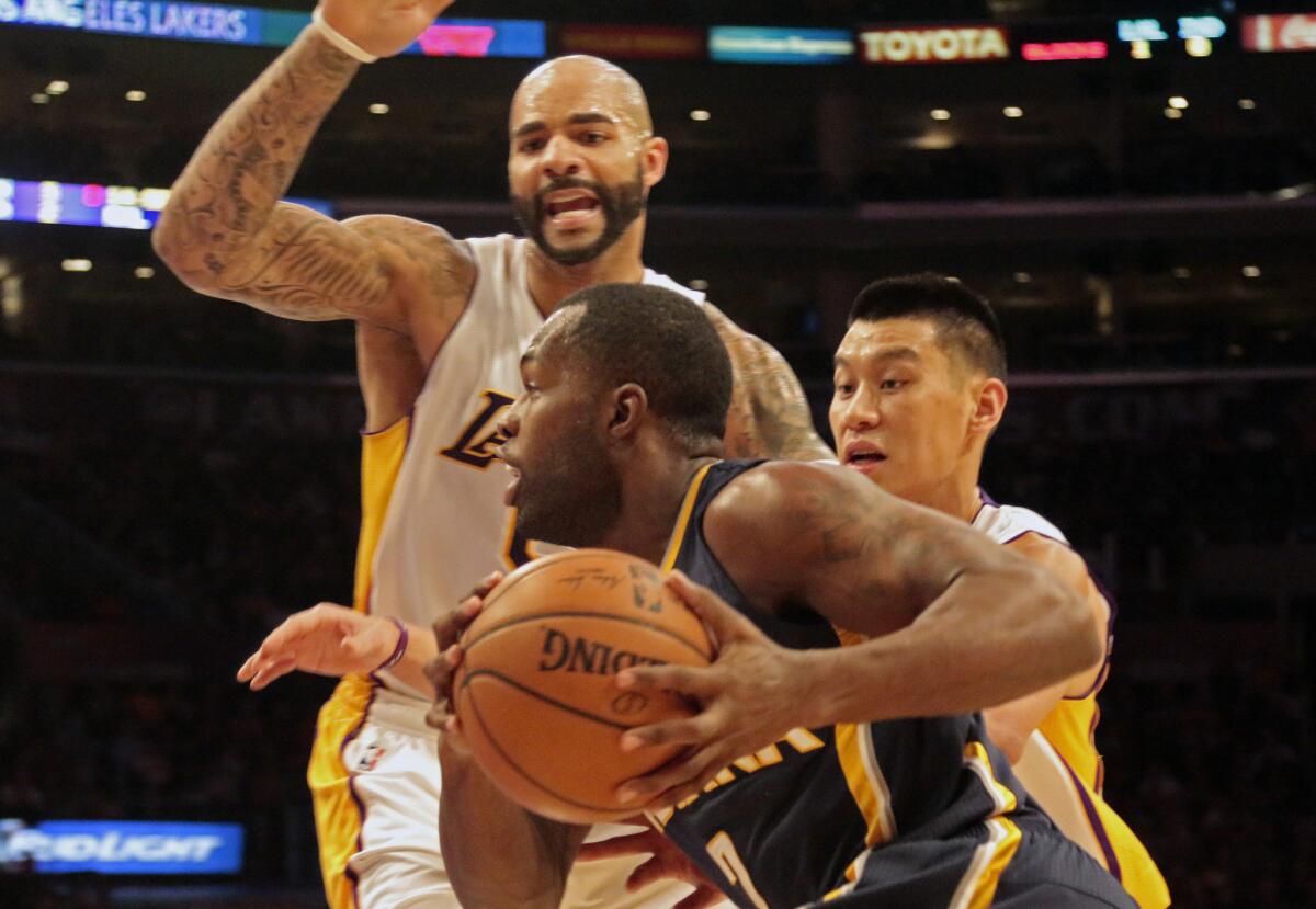 Lakers forward Carlos Boozer helps point guard Jeremy Lin cut off a drive by Pacers guard Rodney Stuckey on Sunday night.