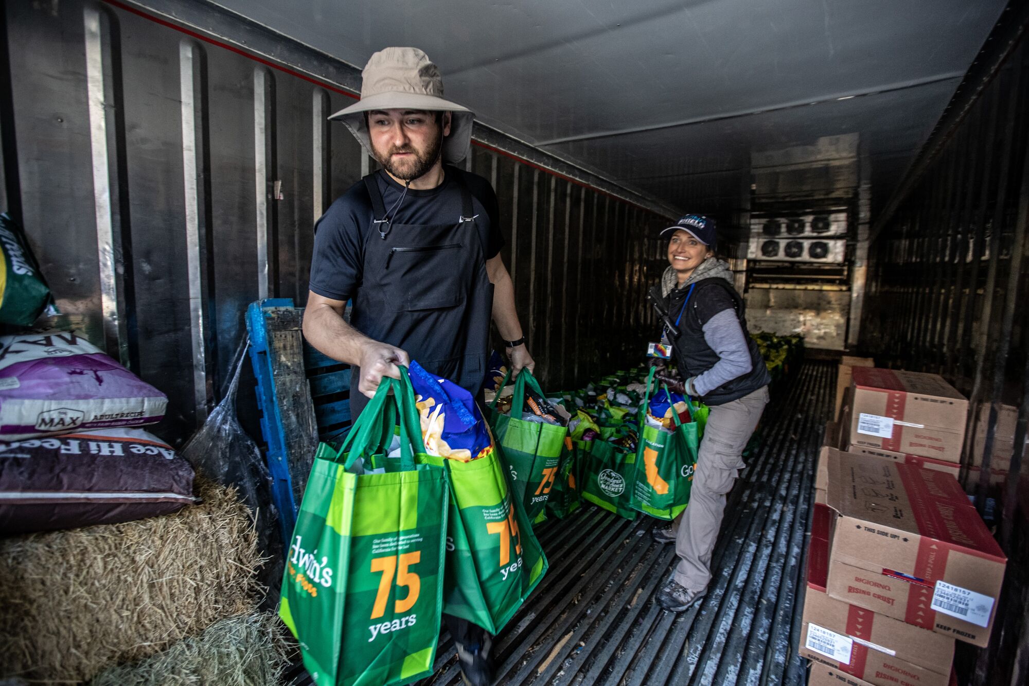 Volunteer Adam Perruzzi carries bags of groceries at a food bank in the Crestline area.