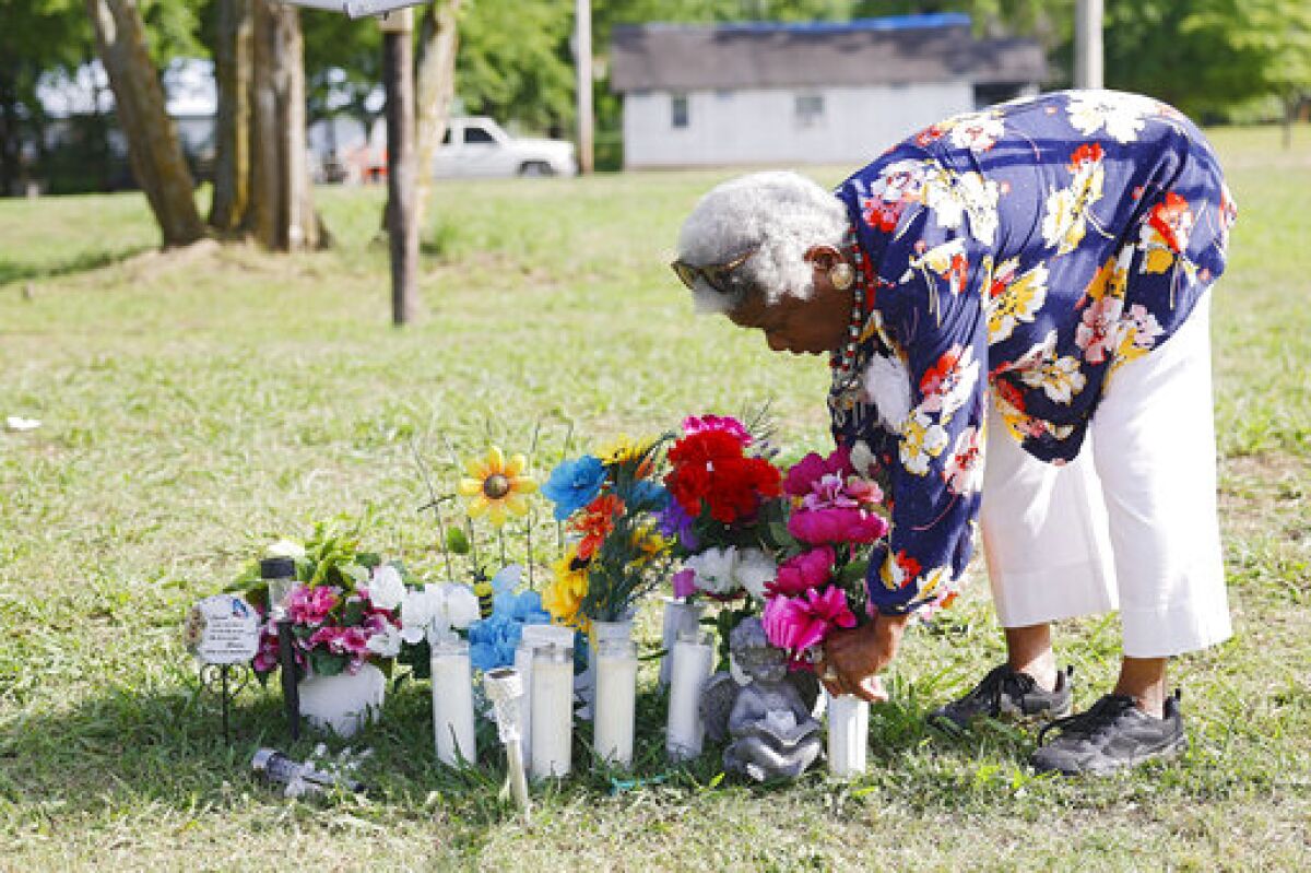Lelia Foley-Davis adds to a makeshift memorial, Tuesday, May 31, 2022, at the site of a mass shooting two days earlier, in Taft, Okla., during the town's Memorial Day celebration. Foley-Davis was the first Black woman elected mayor in the United States. (Mike Simons/Tulsa World via AP)