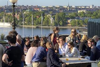 People enjoy drinks and snacks in the evening sun on a terrace overlooking Stockholm, on Tuesday, May 30, 2023. Smoking is prohibited in both indoor and outdoor areas of bars and restaurants in Sweden, which has the lowest share of smokers in the European Union. (AP Photo/Karl Ritter)