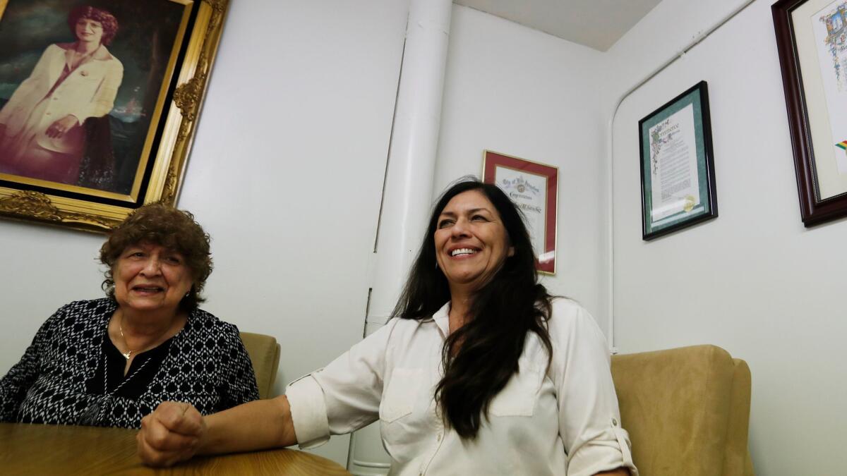 Dolores Sanchez and her daughter Gloria Alvarez smile in an office.