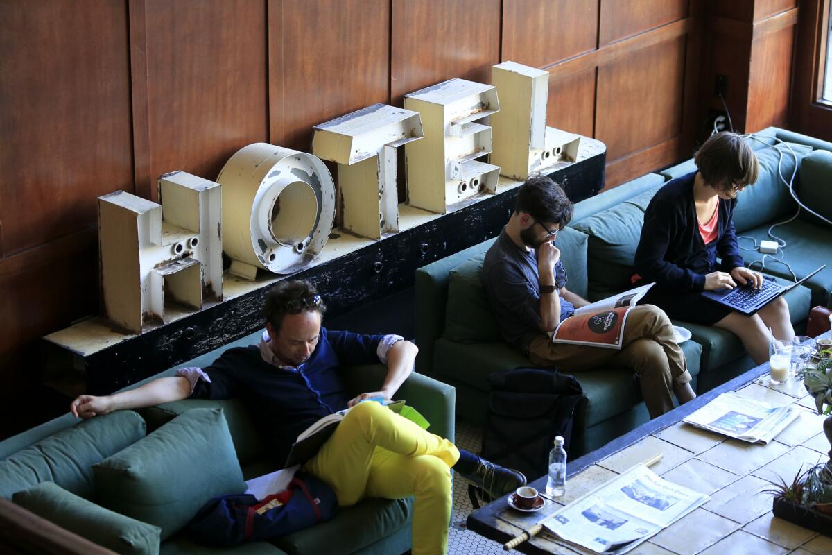 Travelers wait in the lobby of the Ace Hotel in downtown Portland. Hotel experts predict hotel rates will rise only 5% this year, partly because hotel operators don't want to scare off foreign visitors whose currency has lost value compared with the U.S. dollar.