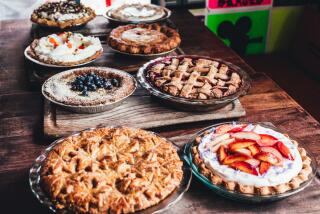 An assortment of pies on a dark wood table.
