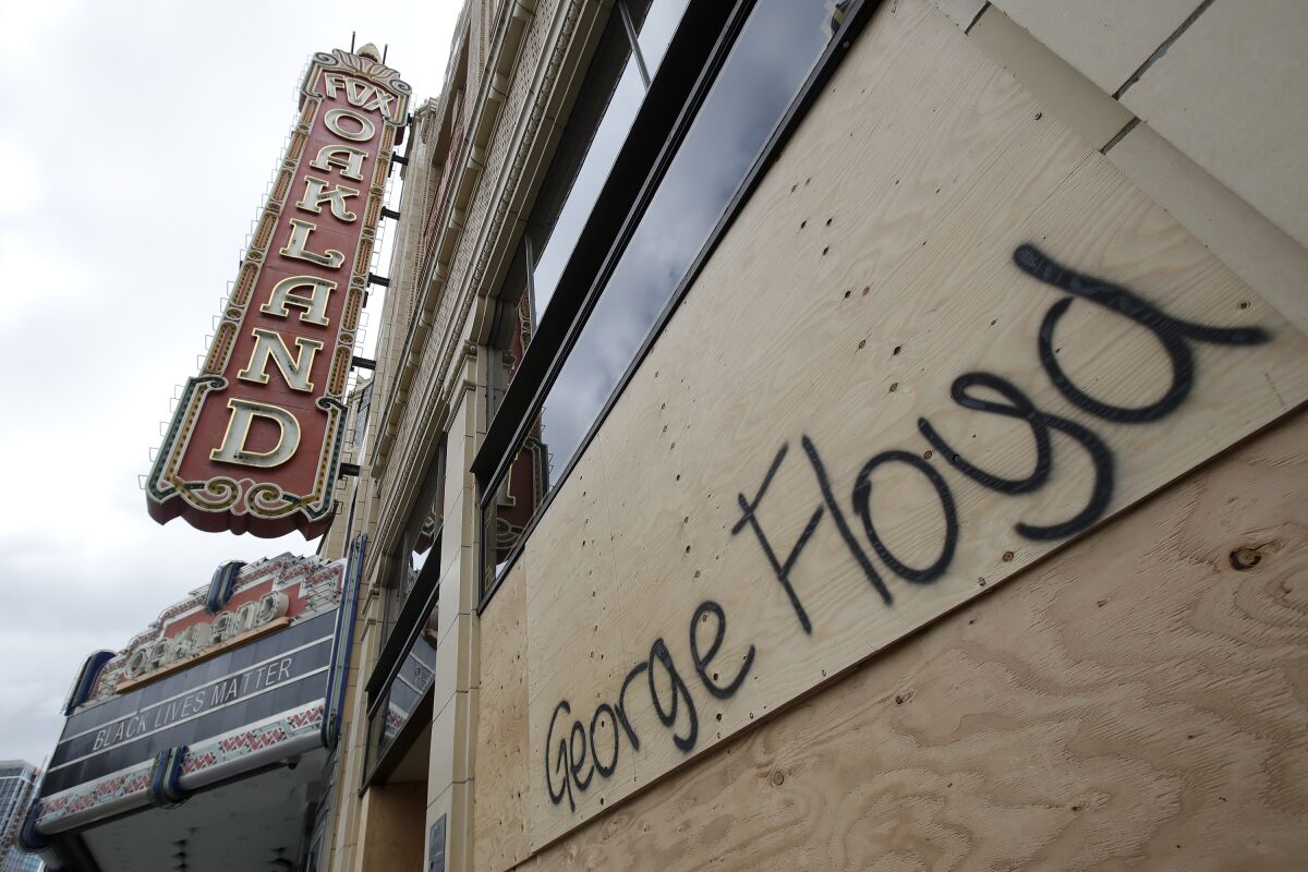 George Floyd's name is written on a boarded-up window at the Fox Theater in Oakland, Calif.