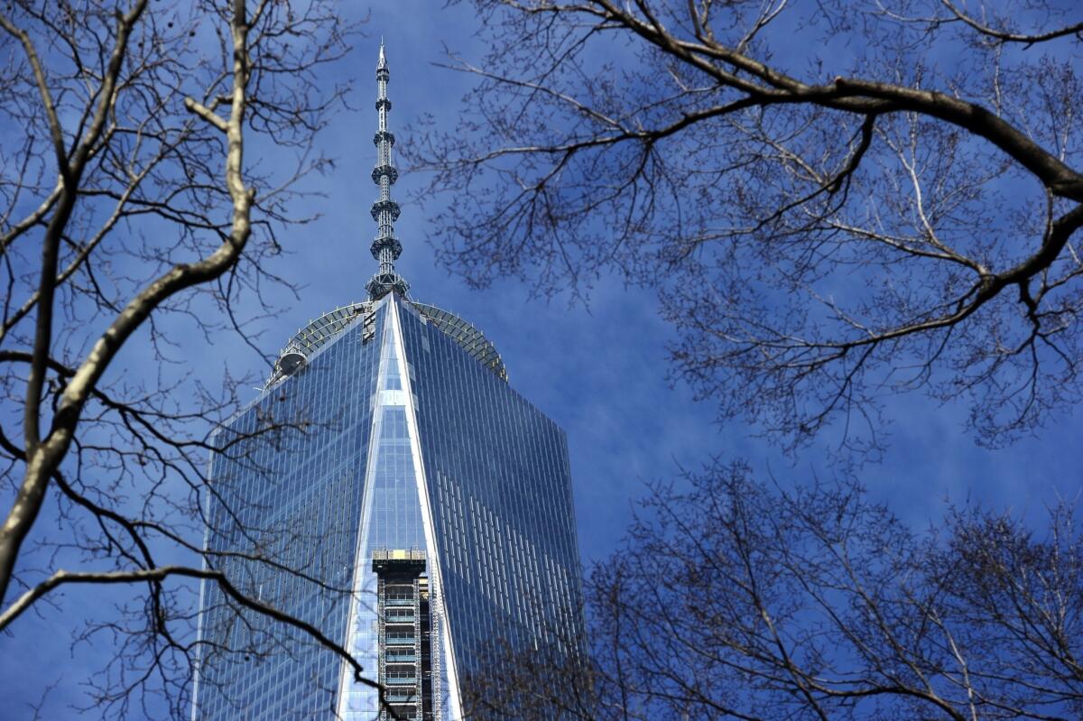 The top of One World Trade Center and its spire are seen through trees at St. Paul's Chapel in Lower Manhattan.