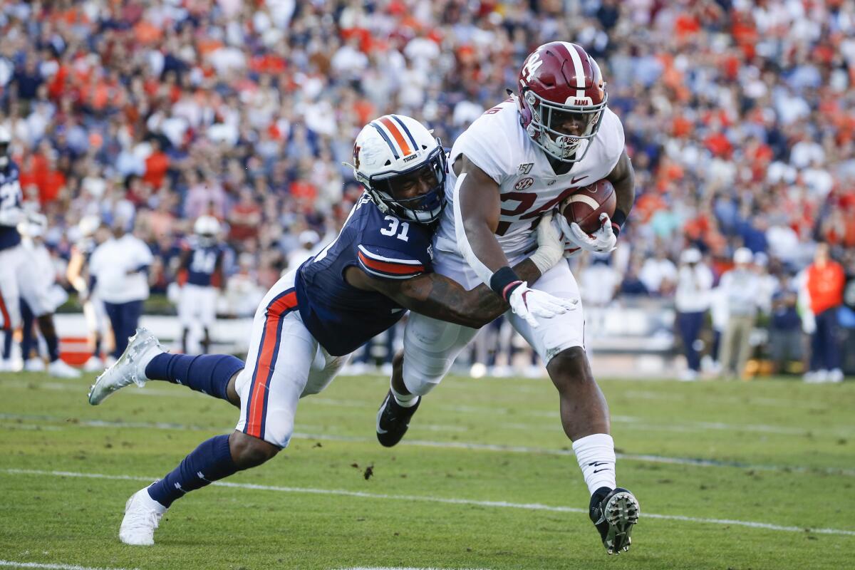 FILE - Alabama running back Brian Robinson Jr. (24) carries the ball as Auburn linebacker Chandler Wooten (31) tries to tackle him during the first half of an NCAA college football game in Auburn, Ala., in this Saturday, Nov. 30, 2019, file photo. Wooten’s experience should provide a boost for Auburn as the Tigers attempt to replace Tampa Bay Buccaneers fifth-round draft pick K.J. Britt at linebacker. Wooten had 10 tackles in 2018 and 27 more in 2019.(AP Photo/Butch Dill, File)