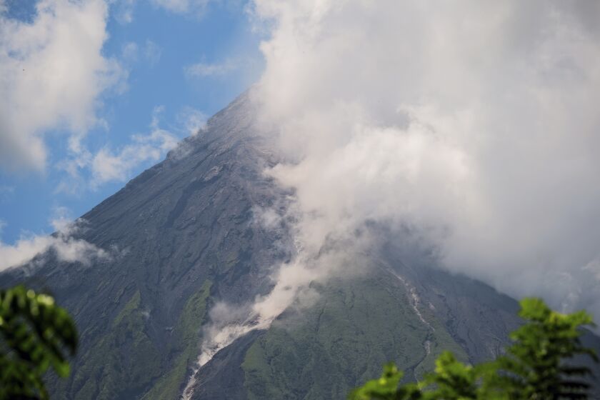 El volcano Mayon arroja una nube de humo blanco, visto desde Daraga, en la provincia de Albay, en el centro de Filipinas, el 8 de junio de 2023. (AP Foto/John Michael Magdasoc)