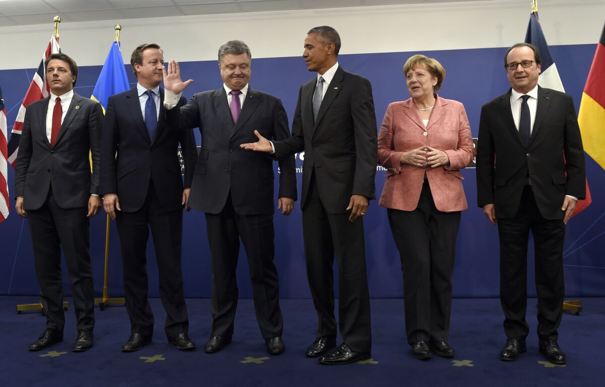 President Obama reaches for the hand of Ukrainian President Petro Poroshenko at the NATO summit in Warsaw with, from left, Italian Prime Minister Matteo Renzi, British Prime Minister David Cameron, German Chancellor Angela Merkel and French President Francois Hollande.