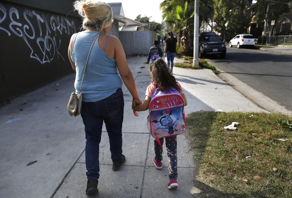 Brenda Ramirez, left, walking home from school with Emely, says she plans to get counseling for her daughter through her elementary school.