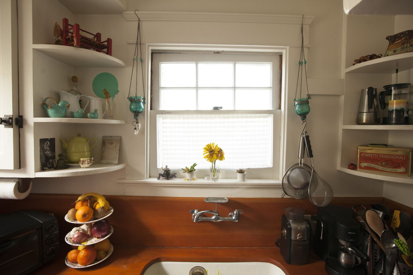The galley-style kitchen features wood countertops and open shelves.