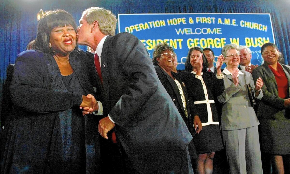 Marva Smith Battle-Bey receives a kiss from President George Bush in 2002. Smith Battle-Bey, an urban planning expert, was instrumental in bringing development to South L.A. over three decades.