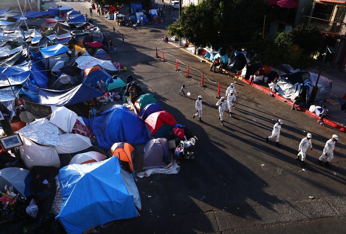 Mexican National Guard soldiers walk past tents on the Mexican side of the San Ysidro Port of Entry