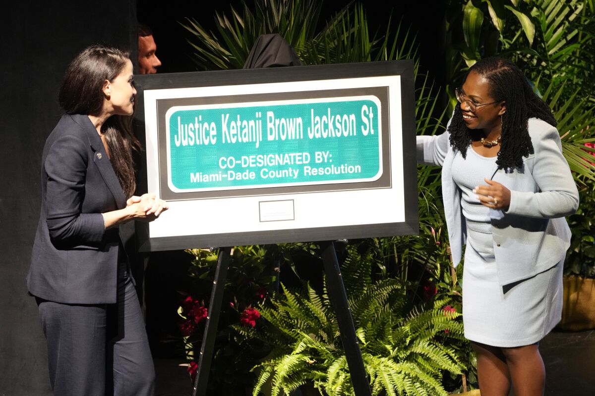 Supreme Court Justice Kentanji Brown Jackson looks at a street sign named in her honor
