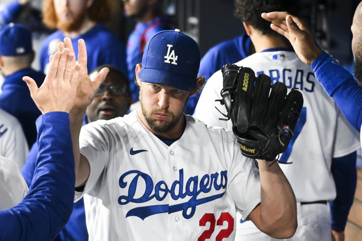 Dodgers starting pitcher Clayton Kershaw celebrates in the dugout during a game.
