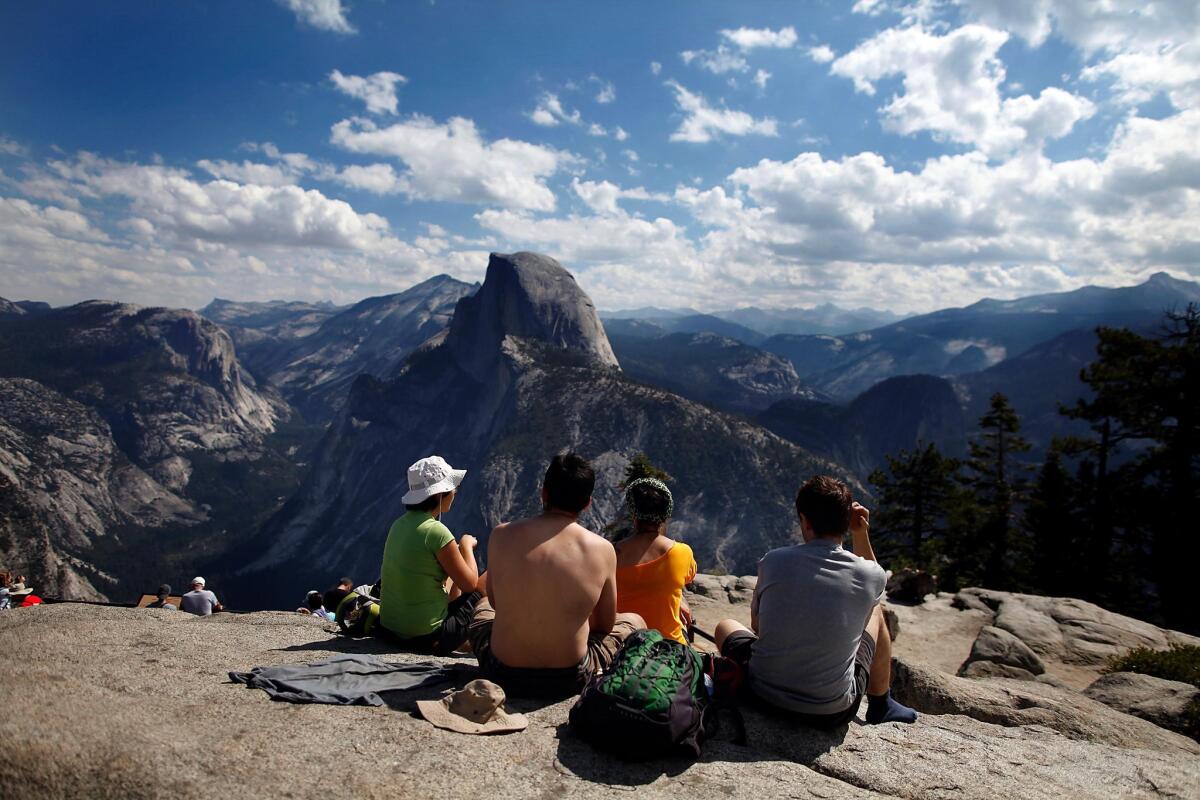 Visitors enjoy the grand view at Glacier Point in Yosemite National Park. The road to the overlook opens Tuesday.
