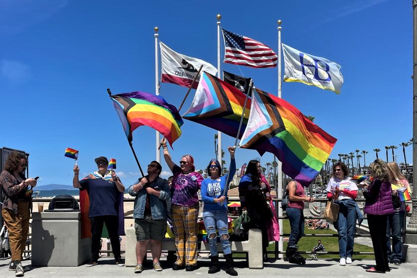 Local activists and members of the queer community have been waving pride flags at the Huntington Beach Pier each Sunday.