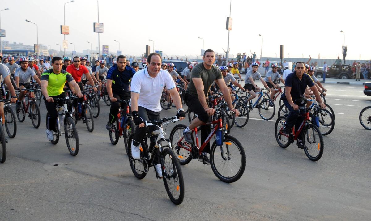 A handout picture made available on Friday by the Egyptian presidency shows President Abdel Fattah Sisi, center left, taking part in a cycling marathon in Cairo.