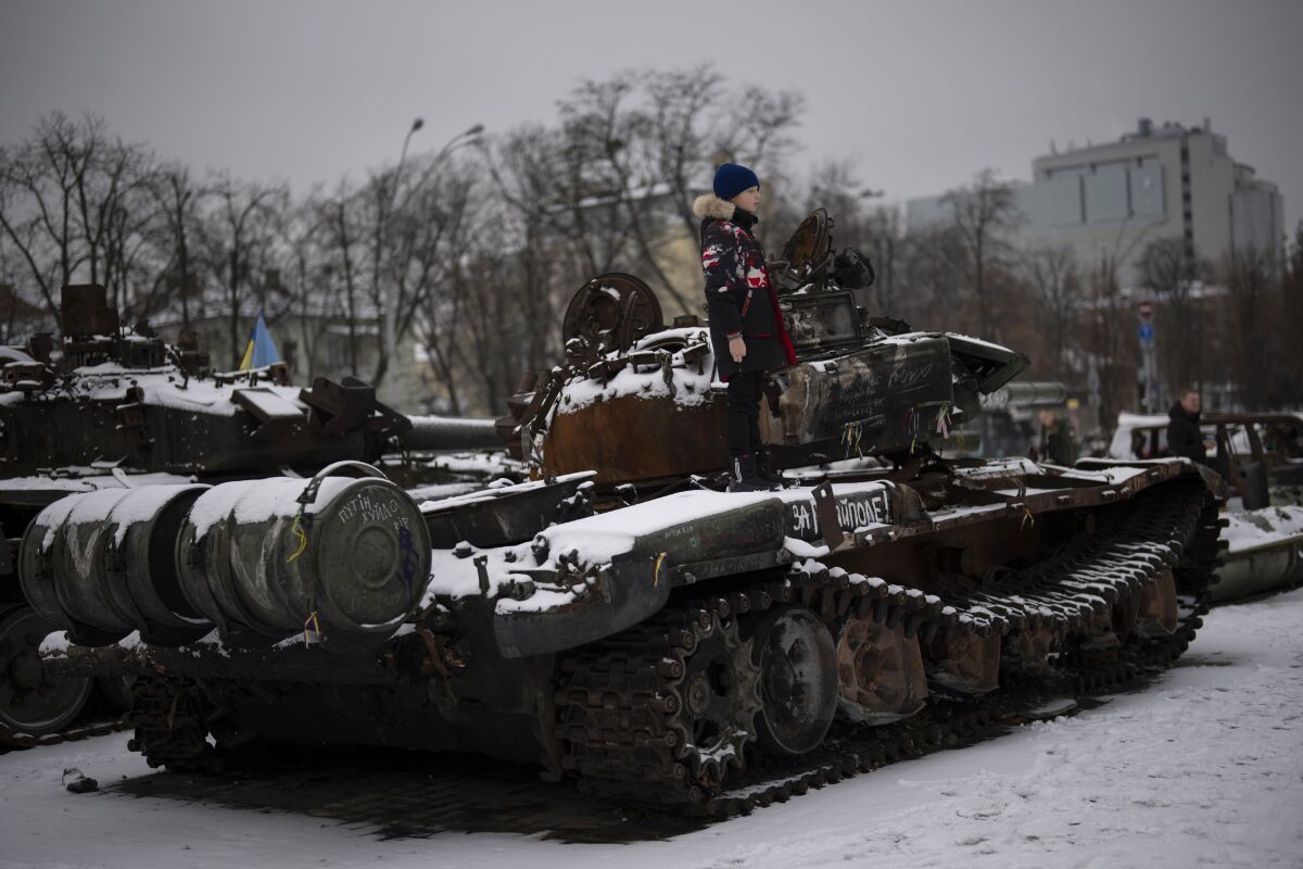 Un niño subido a un tanque ruso destruido y expuesto en el centro de Kiev, Ucrania,