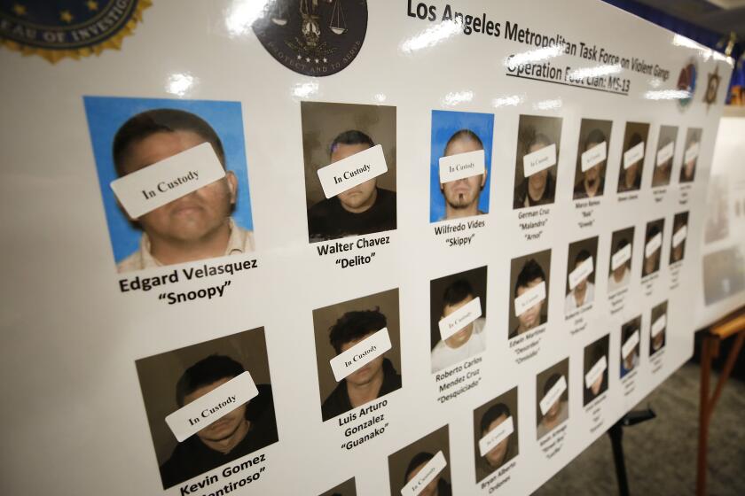 A poster of defendants in custody is seen as law enforcement officials announce the unsealing of a federal racketeering indictment targeting Los Angeles-based members of MS-13 on July 16.