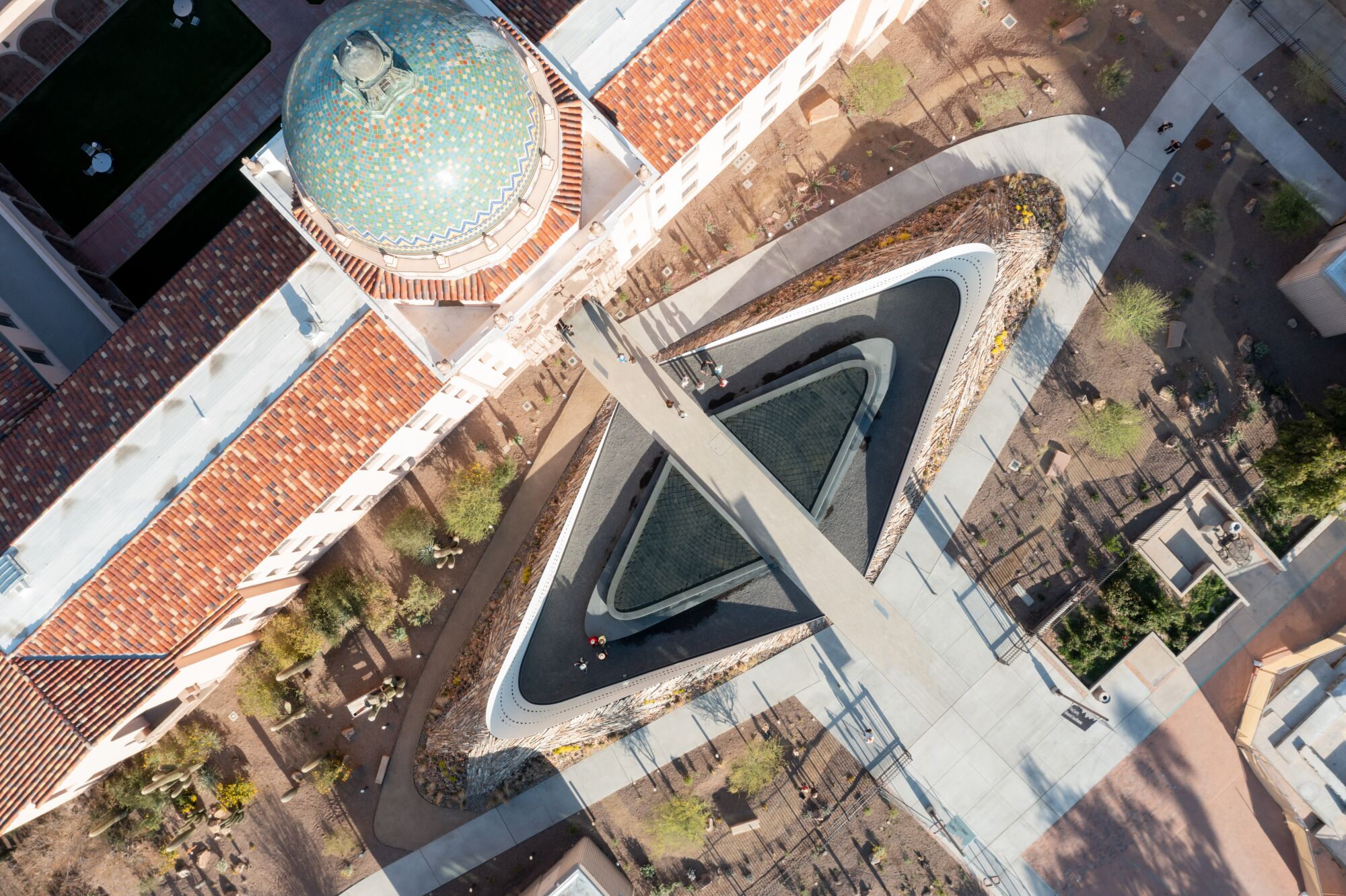 An overhead shot of a building with a dome and two triangular shapes in the land.