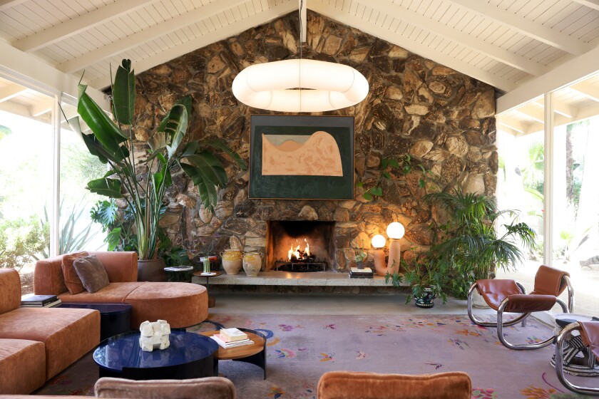 The lobby at Ojai's Capri Hotel features a stone-faced fireplace, seating area and plants.