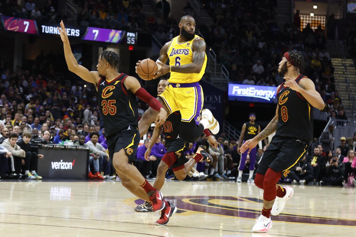 LeBron James looks to pass against Isaac Okoro, left, and Lamar Stevens.