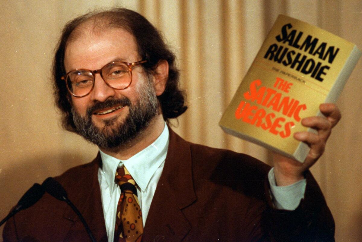 Author Salman Rushdie holds up a copy of his controversial book "The Satanic Verses" in 1992.