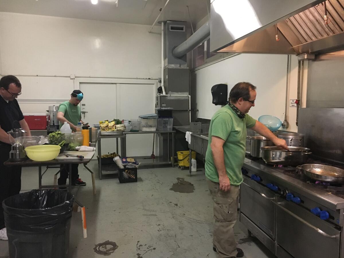 Ed Burke, left, Will Gross and Andy Wild help out at a shelter's kitchen in Calistoga, Calif.