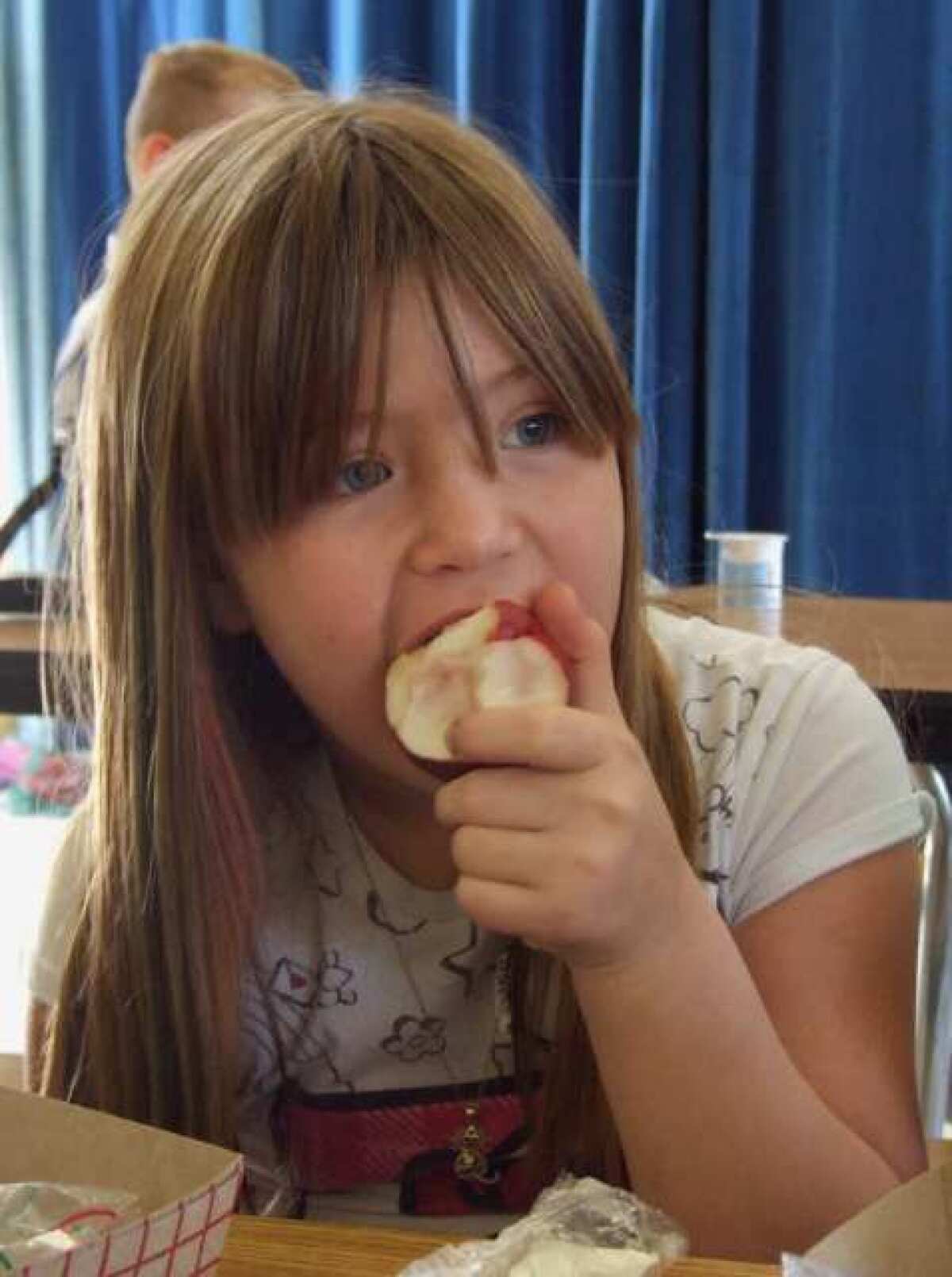 Alyssa Arceo, a third-grader at Julien School in Turlock, Calif., enjoys an apple.